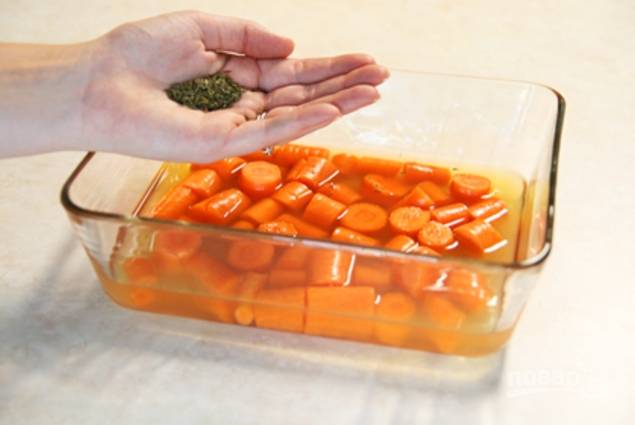 Положите морковь в форму для запекания, залейте бульоном, добавьте ароматные травы и немного соли.
