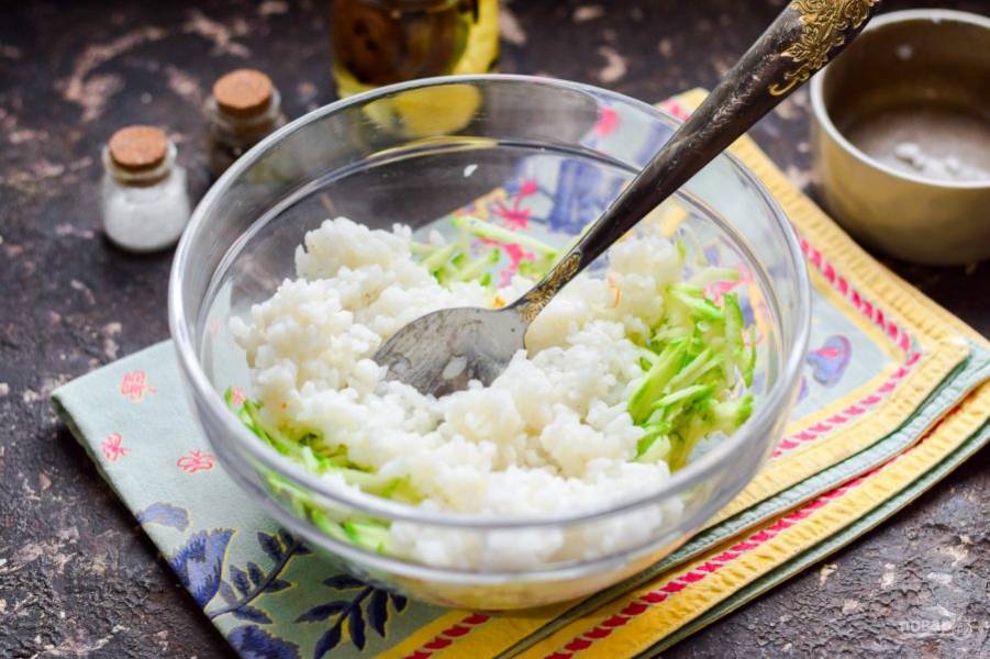 Переложите к кабачкам готовый рис, добавьте соль и перец по вкусу.