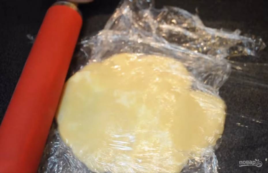 2. Положите тесто в пакет и отправьте в холодильник минимум на час. Спустя час приступите к формированию коржа. Для этого обложите тесто с двух сторон пищевой пленкой, чтобы оно не прилипало к поверхности.