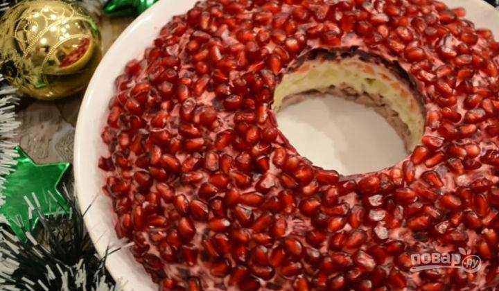 Салат украсьте гранатовыми ядрами. Из середины достаньте стакан. Можно есть блюдо сразу же, а можно оставить его в холодильнике, чтобы он больше пропитался. Приятного аппетита!