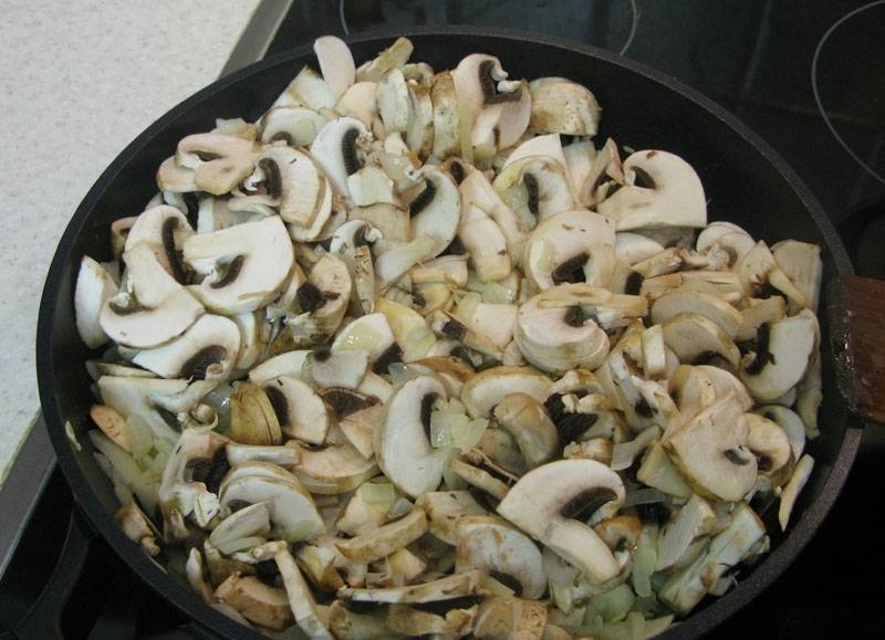 3. Тем временем займемся соусом. На сковороде растапливаем сливочное масло, обжарим лук. Когда станет прозрачным, - добавим грибы, и жарим все вместе, пока жидкость из грибов не испарится.