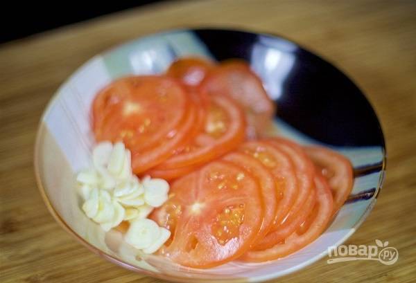 7. Очистите и нарежьте тонкими пластинками чеснок, ломтиками — помидоры. Натрите сыр на терке. 