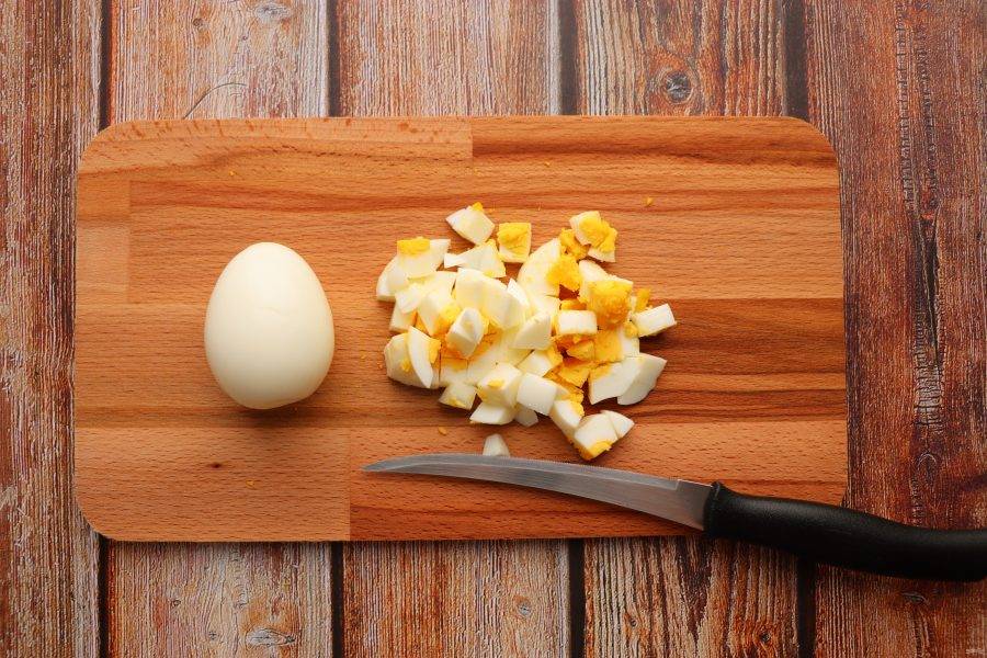 Яйца сварите вкрутую, очистите и нарежьте кубиками.