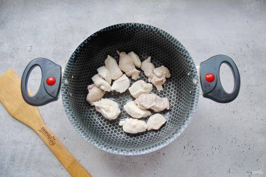 Филе индейки нарежьте кусочками и выложите в кастрюлю с подсолнечным маслом. Обжарьте мясо до изменения цвета.