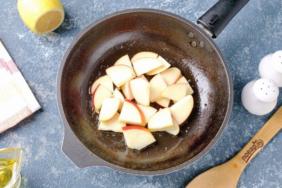 Переложите печень на тарелку, а в эту же сковороду выложите нарезанное небольшими дольками яблоко.