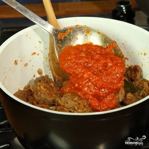 Спустя пару минут добавляем томатную пасту и немного воды. Готовим на медленном огне примерно 50 минут (если соус будет слишком густым - подливайте воду). За это время говядина дойдет до готовности.