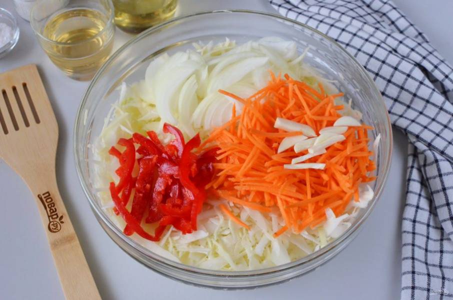 Порежьте лук полукольцами, чеснок пластинками, морковь натрите на крупной терке, сладкий перец порежьте соломкой. Добавьте овощи к капусте.