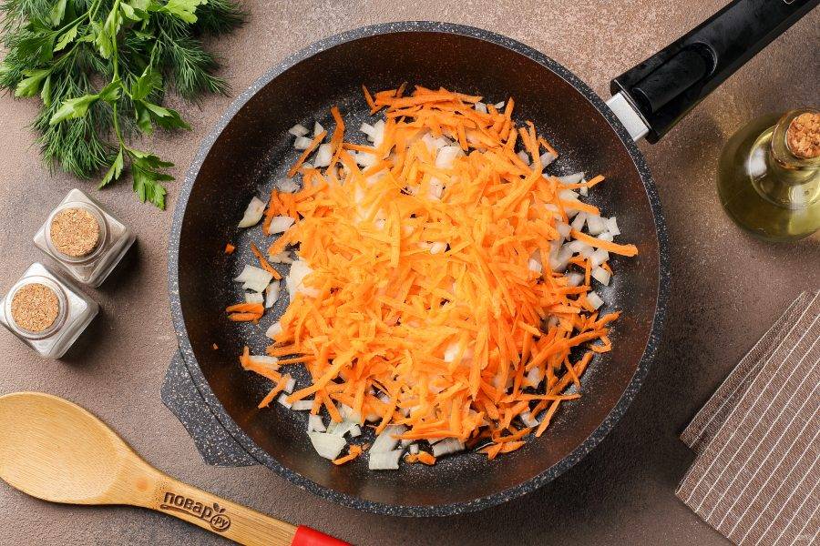 Разогрейте сковороду с маслом. Выложите нарезанный кубиками лук и тёртую морковь.