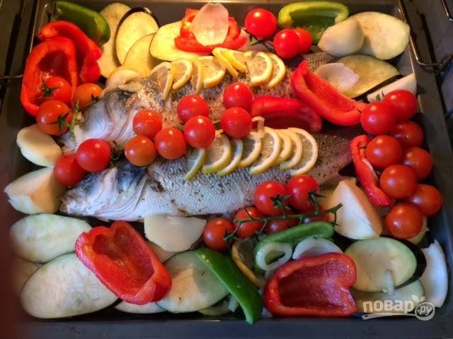 5. Достаньте противень и аккуратно удалите фольгу. Распределите вокруг рыбы овощи и отправьте обратно в духовку. Запекайте еще минут 10-25 до полной готовности. 