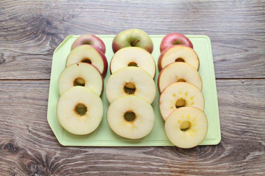 У яблок выровните дно, чтобы яблоко устойчиво стояло. Затем порежьте его на кружочки толщиной 0.5 сантиметра. Удалите сердцевину. 
