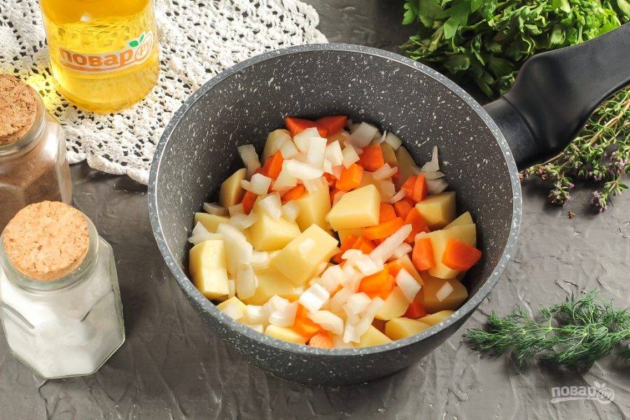 Картофель нарежьте средними кубиками, а морковь и лук — мелкими. Всыпьте в казан или ковш, кастрюлю.