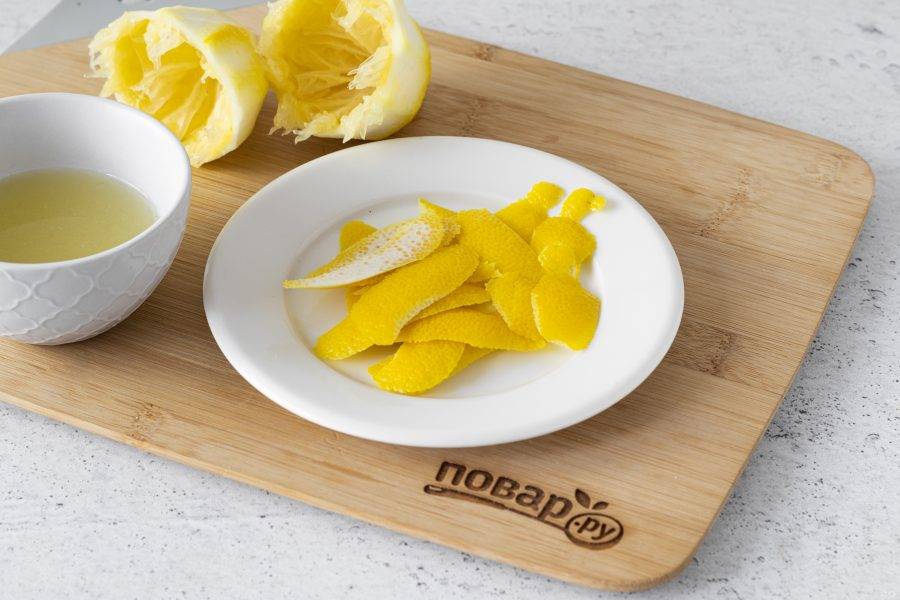 Лимон тщательно помойте и обдайте кипятком. Срежьте с помощью овощечистки желтую часть шкурки. Затем разрежьте лимон пополам и выжмите сок.