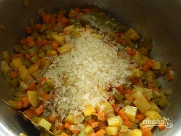 Затем добавляем рис. Перемешиваем и через пару минут добавляем кипяток или бульон, солим по вкусу. Доводим до кипения, накрываем крышкой и варим суп 15 минут.