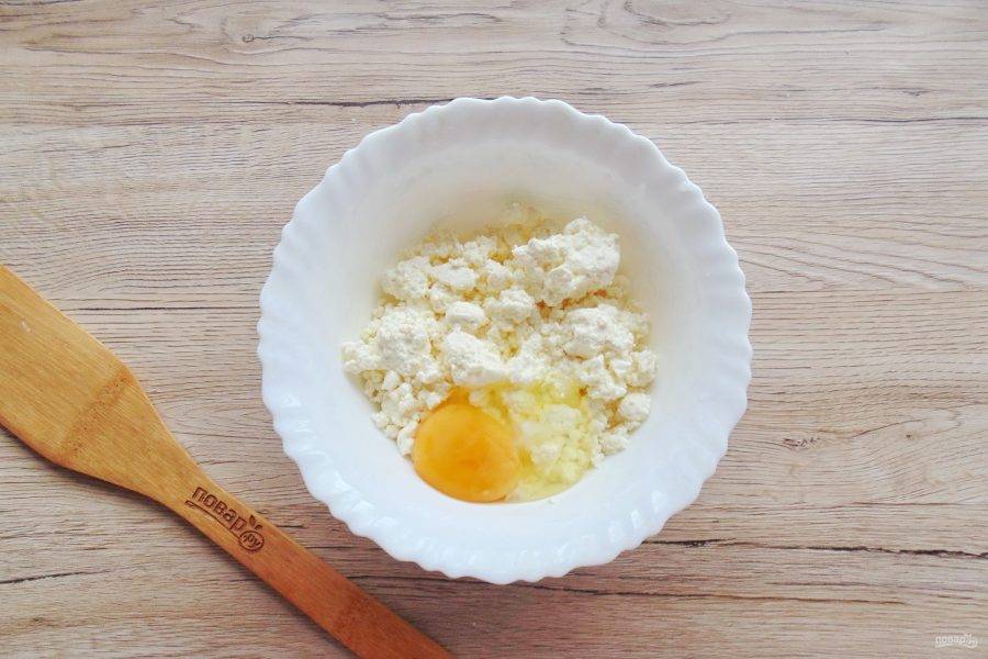 В миску выложите творог и яйцо.