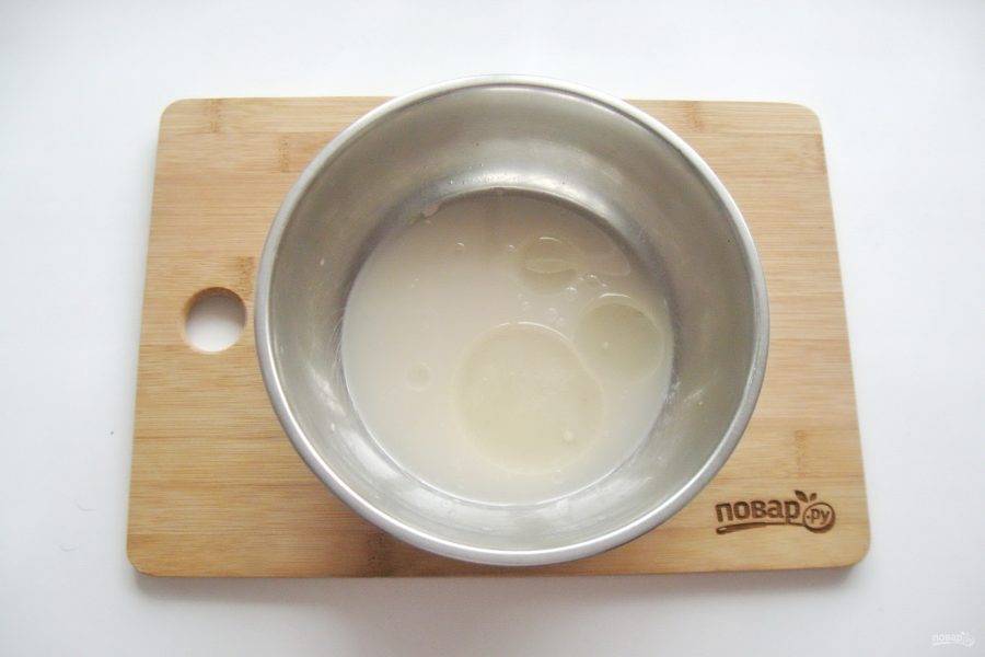 В миску налейте теплую воду. Добавьте дрожжи, сахар и две столовые ложки подсолнечного масла.