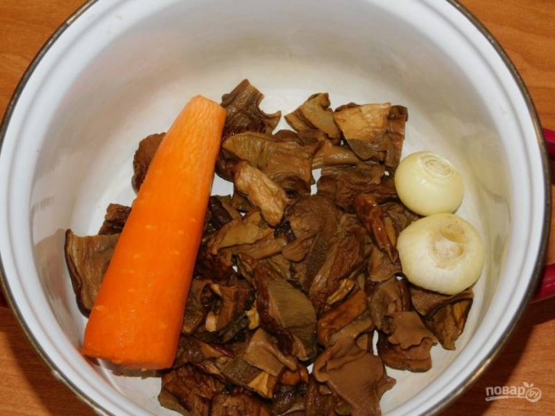 Выложите грибы в кастрюлю. Добавьте морковь и лук. Залейте водой и доведите до кипения.