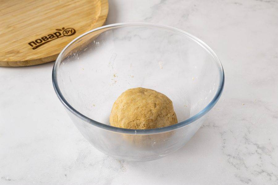 Влейте постепенно воду и замесите однородное тесто. Скатайте его в шар, заверните в пленку и уберите в холодильник на 30 минут. 
