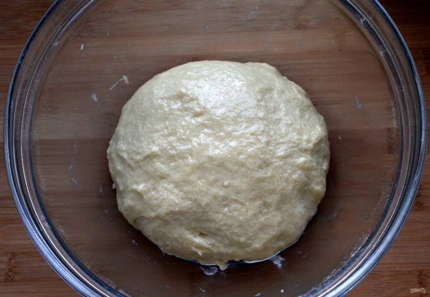 Готовое тесто скатайте в шар, смажьте маслом и выложите в миску. Затяните миску пищевой пленкой и уберите в теплое место до увеличения объема в три раза.

