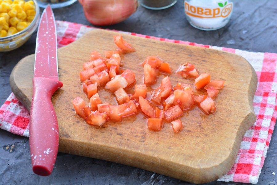 Нарежьте кубиками помидоры.