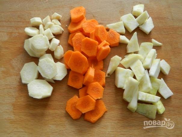 2. Затем очистим корень петрушки, сельдерей и морковку. Нарезаем их небольшими кусочками и добавляем к луку. Помешивая тушим минут 10.