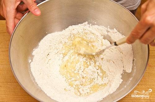 В отдельную удобную миску просеиваем муку, добавляем соль, сахар. Перемешиваем. Затем в сухую смесь вливаем жидкую смесь и при помощи вилки перемешиваем.