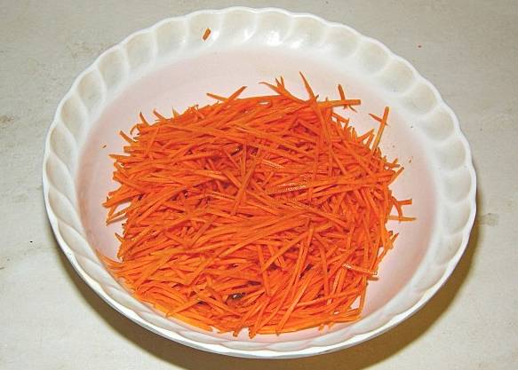 Морковь натрите на терке для корейской моркови. Посолите и перемешайте.