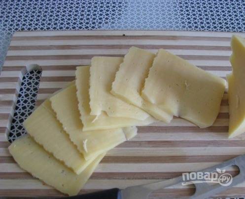 Пока мясо с ананасами запекается, нарежьте ломтиками в полсантиметра толщиной твердый сыр. Вы можете выбрать любой сорт на ваше усмотрение, например, Моцареллу, Радомер или Маасдам. 