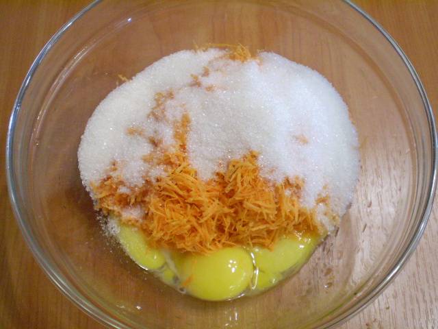 Берем глубокую посудину. Насыпаем туда сахар, добавляем тертую на мелкой терке морковь и желтки яиц. Перемешиваем.