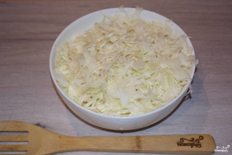 Для приготовления блюда необходимо нашинковать белокочанную капусту тонкой полосочкой. Сложите её в миску.