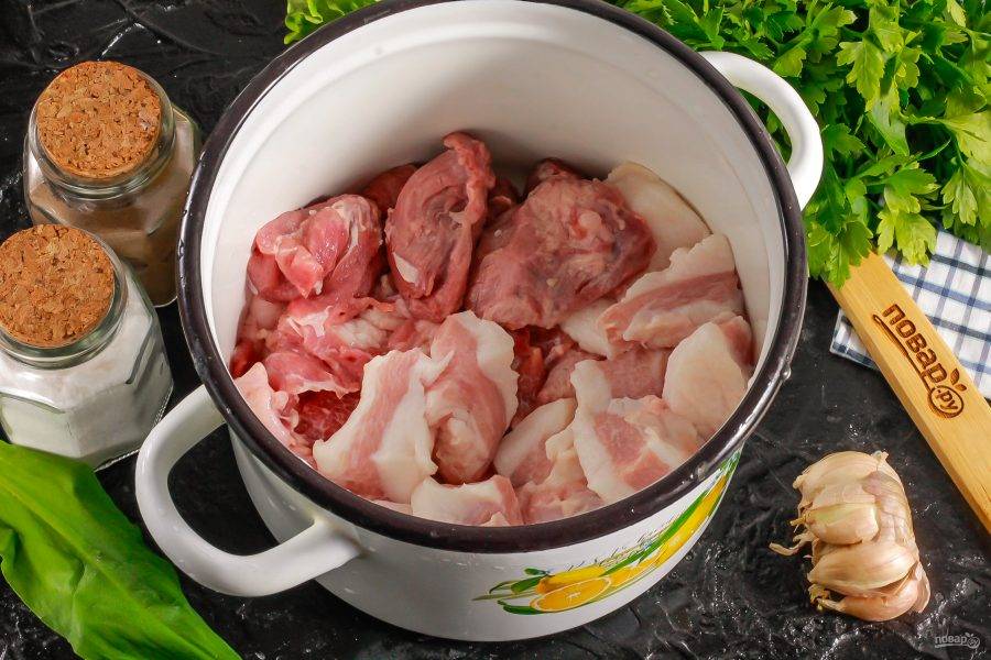 Промытое и зачищенное мясо говядины и свинины нарежьте крупными кубиками и выложите в кастрюлю. Сюда же добавьте нарезанное сало (подчеревок).