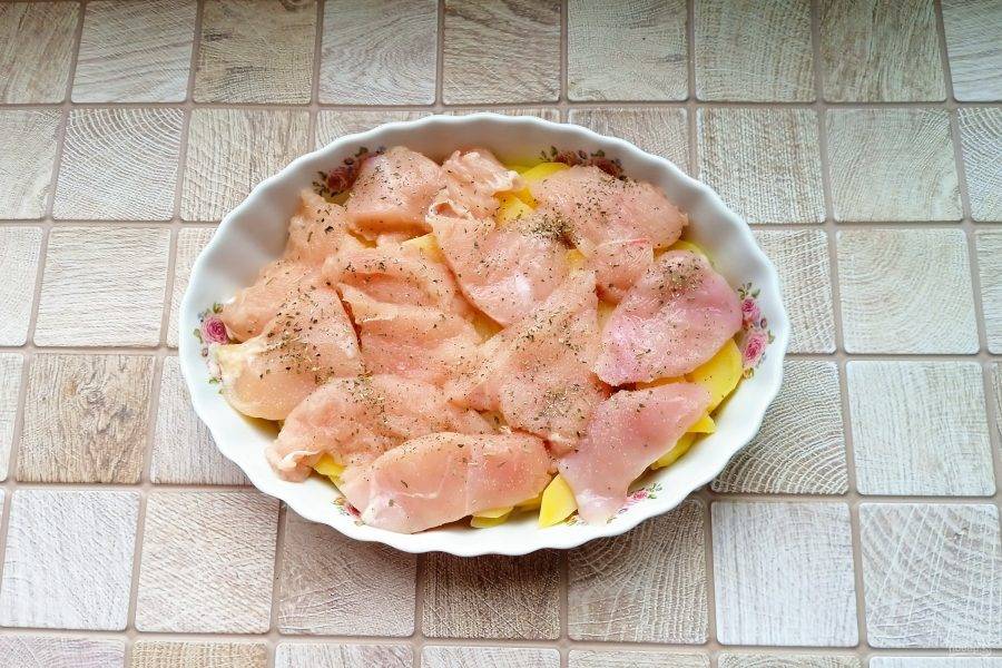 Куриное филе нарежьте небольшими пластинками. Посолите и поперчите. Разложите поверх картофеля.