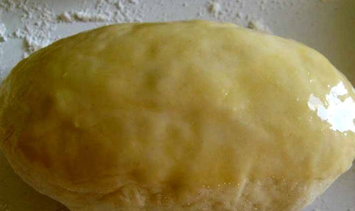 Когда все пирожки будут слеплены, застилаем противень пергаментом и выкладываем на него пирожки швом вниз, смазываем их поверхность взбитым яйцом. 