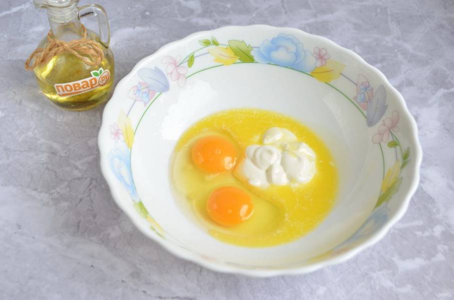 3. Яйца соедините со сметаной и растопленным маслом, вилочкой или венчиком взбейте.