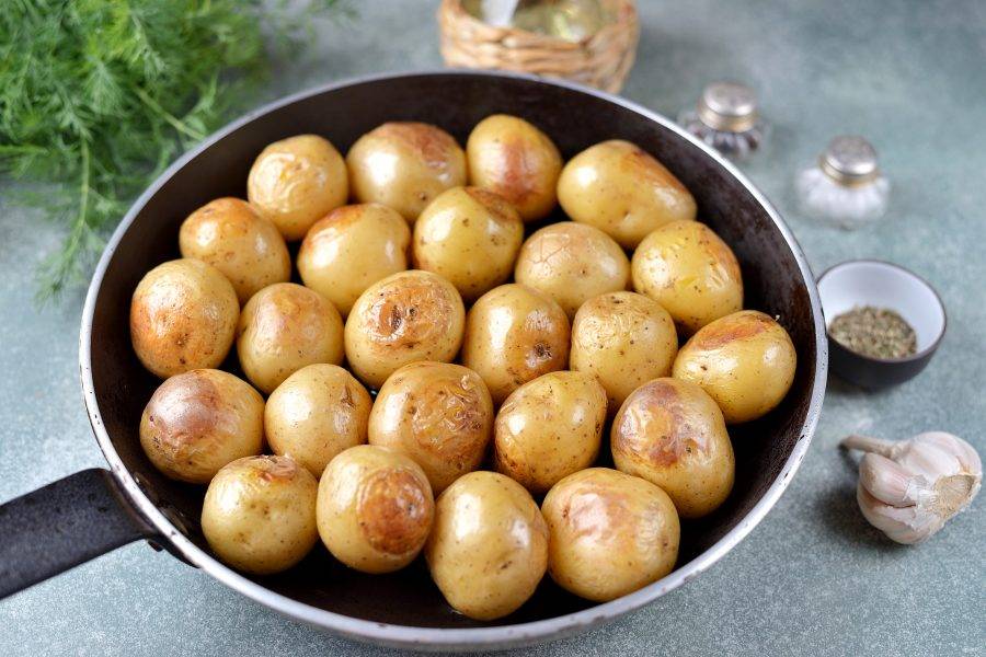 Спустя время достаньте сковороду из духовки, каждую картофелину нужно перевернуть, поскольку внизу она хорошо подрумянится. Отправьте картошку в духовку еще на 20 минут.
