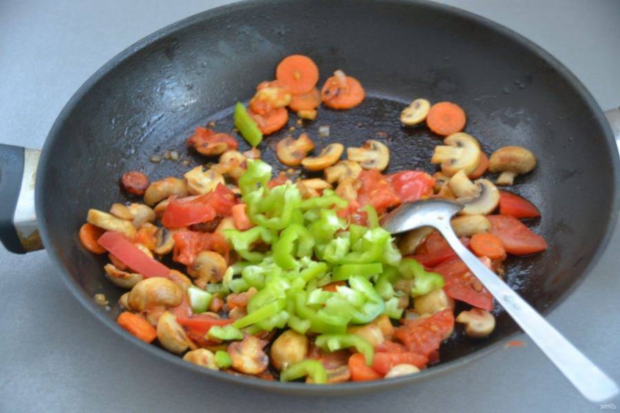 Добавьте в сковороду порезанный помидор и болгарский перец, потушите еще 5 минут.
