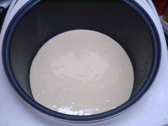 Готовое тесто переливаем в кастрюлю мультиварки. Я смазываю её растительным маслом. Включаем режим "Выпечка", устанавливаем время 50 минут и закрываем крышку.