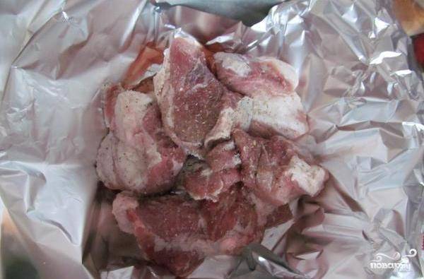Мясо нарезаем на средние кусочки и выкладываем на фольгу. 