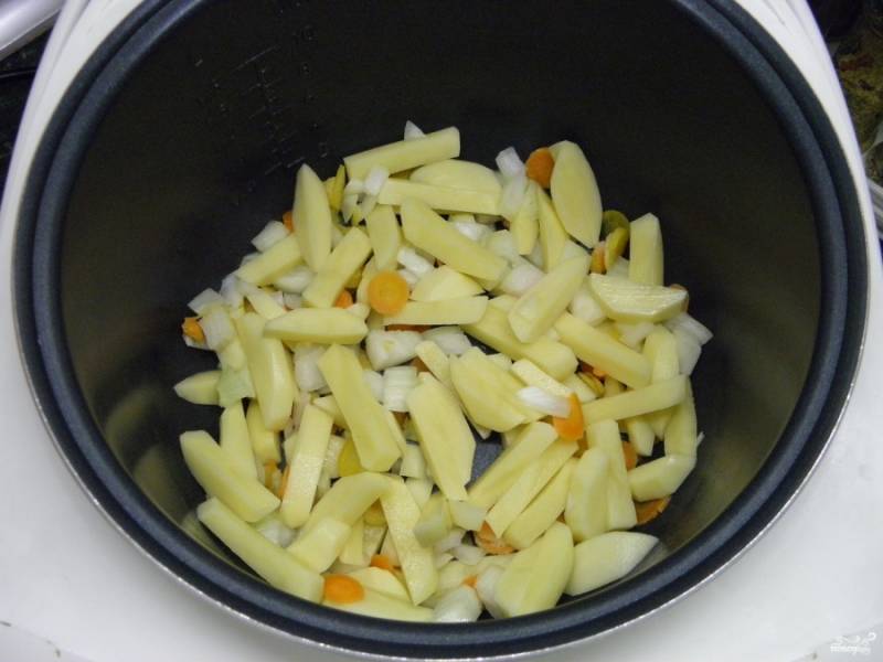 В кастрюлю мультиварки сложите овощи: лук, морковь, картофель. Морковь у меня заранее нарезана кружочками тонко.