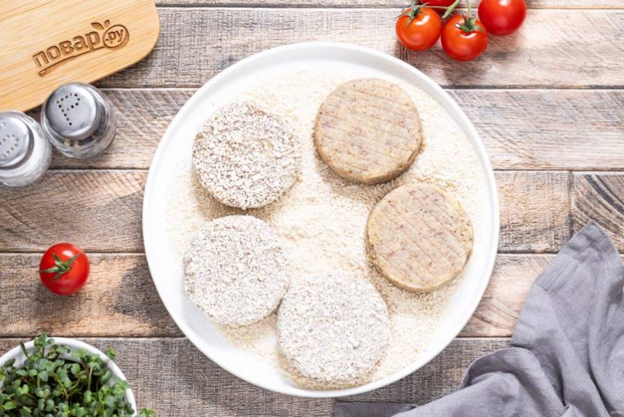 Обваляйте котлеты в панировочных сухарях.