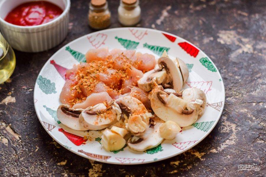 Нарежьте филе индейки небольшими кусочками, грибы пластинами. Посыпьте все специями по своему вкусу.