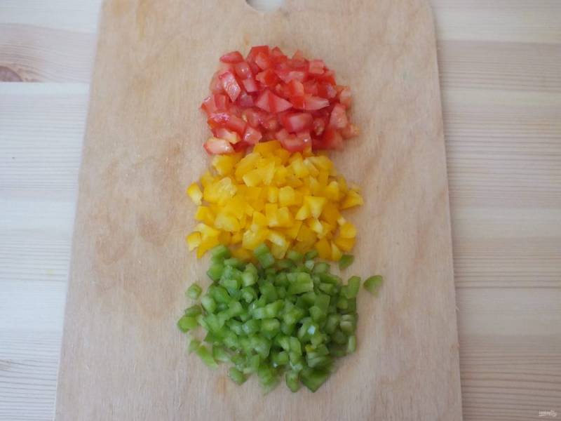 Теперь подготовьте овощи. Помидор и перцы нарежьте мелким кубиком.