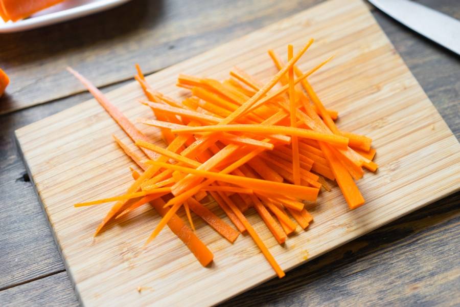 4. Теперь нарезаем соломкой морковку (выбирайте молодую и сладкую) и измельчаем зеленый лук. Тоже отправим все в салат, перемешиваем. 