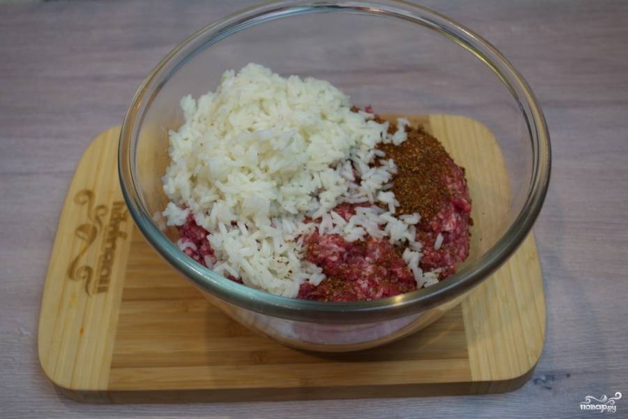 В миску поместите фарш. Добавьте к фаршу слегка проваренный рис (время варки риса 4-5 минут). Измельчите репчатый лук. Добавьте его в емкость к остальным продуктам.