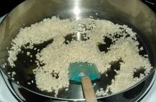 Добавить рис, помешивать, рис станет наполовину прозрачным.