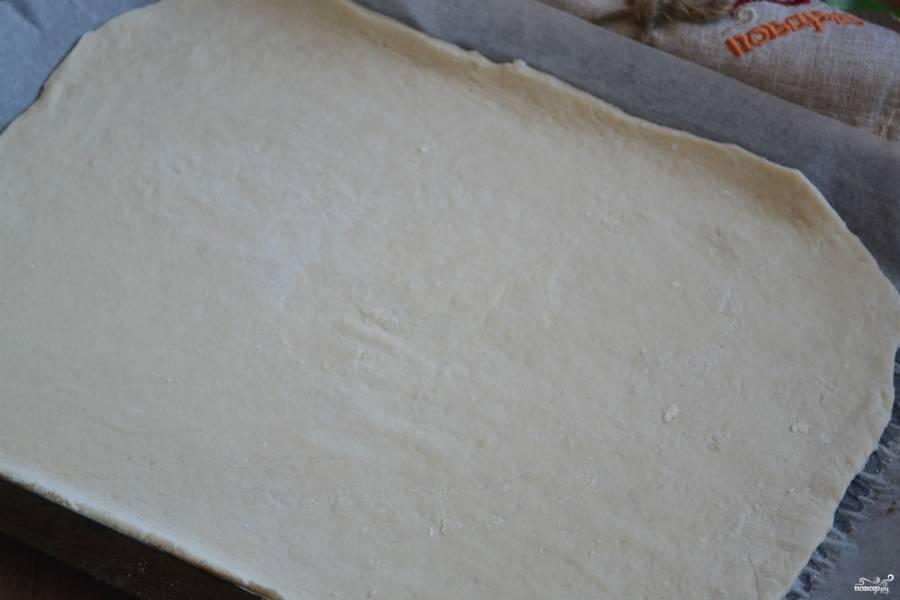 Раскатайте тесто очень тонко, буквально в несколько миллиметров. Выложите его на противень, застеленный пергаментом. 