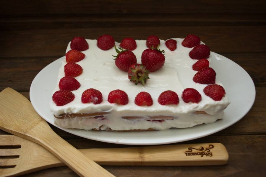 Украсьте сверху ягодами клубники по вашему вкусу и подайте к столу. Торт требует пропитки в холодильнике около 2 часов перед подачей.