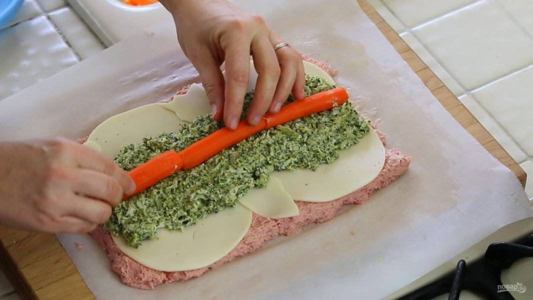 5. Далее на фарш выложите полутвёрдый сыр, брокколи и нарезанную вдоль морковь в центр.