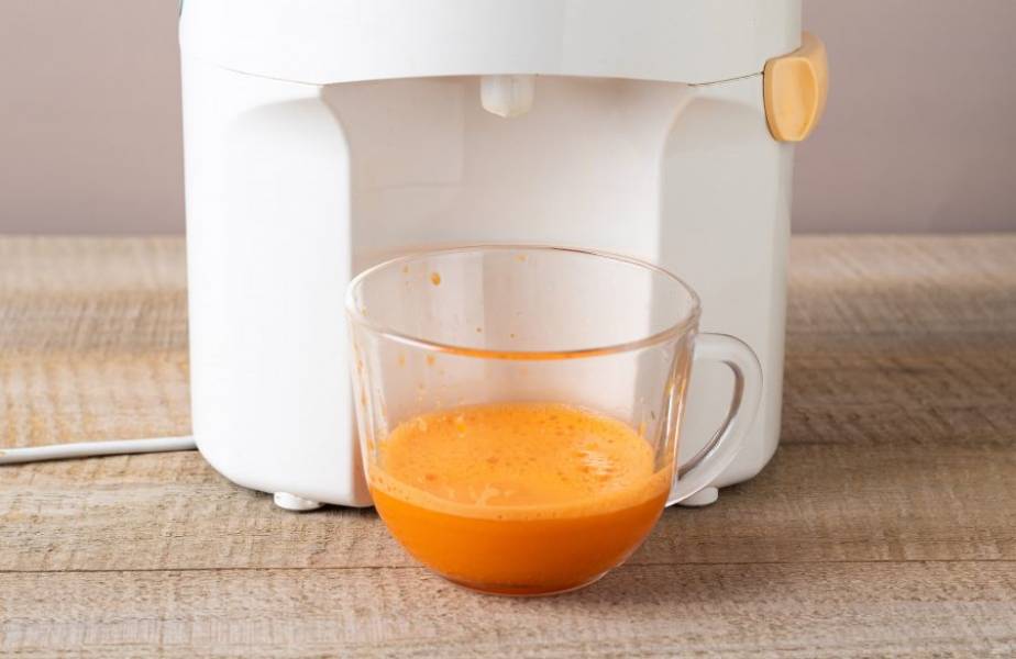 С помощью соковыжималки выжмите сок из моркови.
