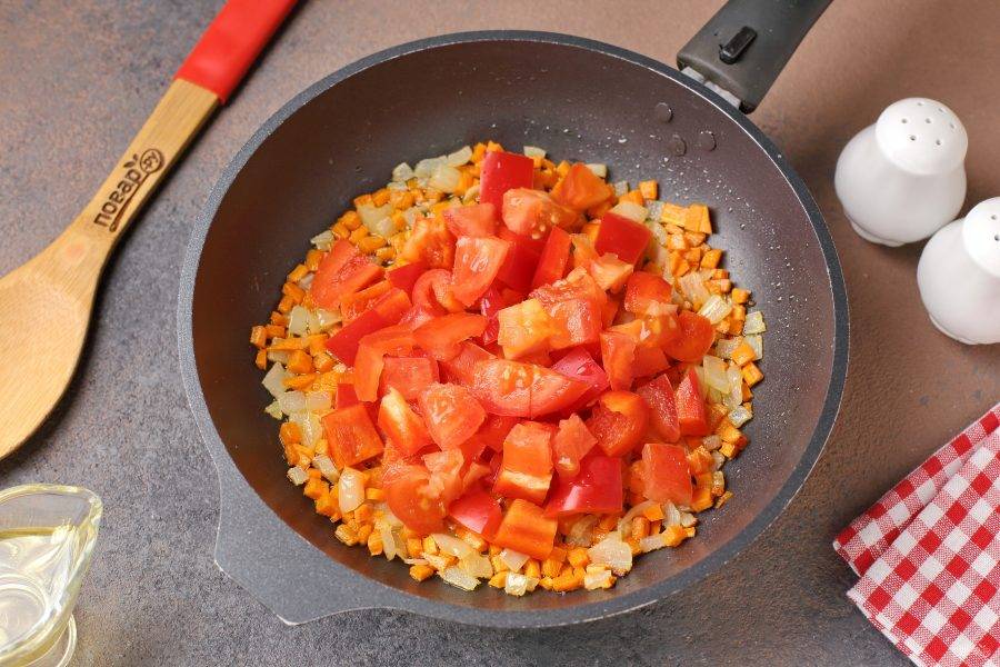 Добавьте нарезанные произвольно болгарский перец и помидор. Тушите всё вместе еще около 3-5 минут.