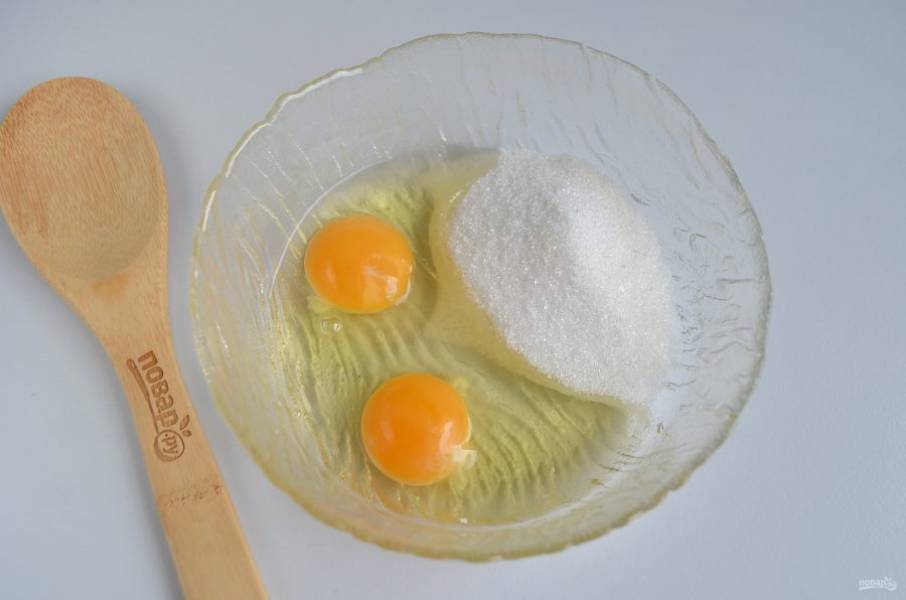 Сначала приготовьте тесто для кростаты. Для этого соедините два яйца с сахаром и щепоткой соли.